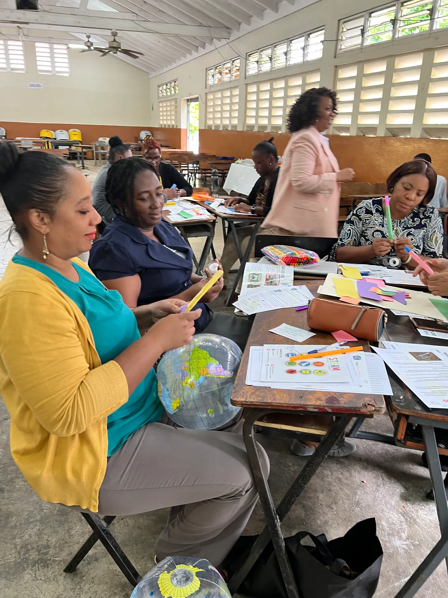 Jamaican educators working together with STEM and reading materials during a collaborative professional development workshop